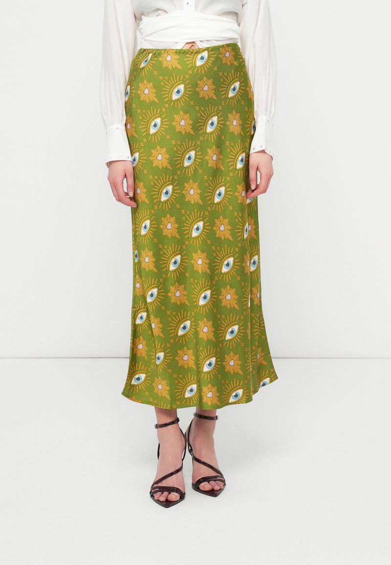 Saia maxi verde claro com um padrão repetido de olhos e flores em amarelo e azul, com uma textura suave e um design fluido.