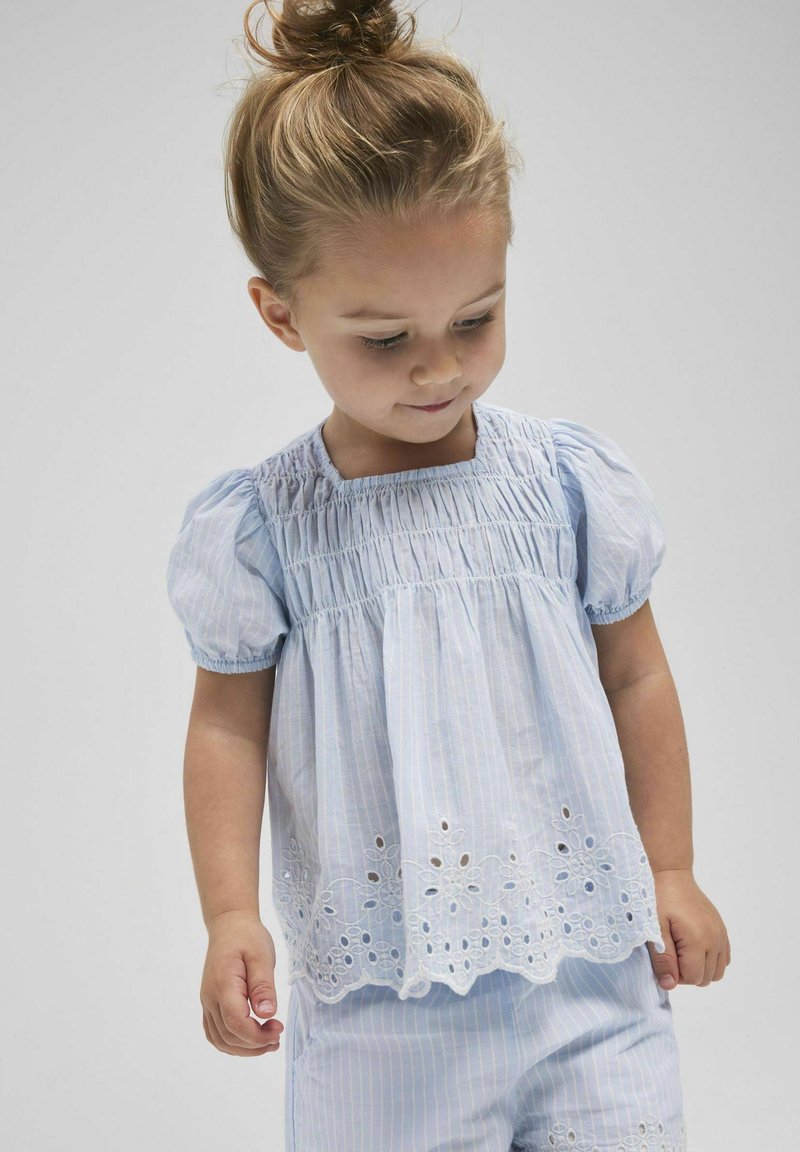 Blusa a righe azzurro chiaro con maniche a sbuffo corte, con yoke arricciato e dettagli in pizzo ad occhiello ricamato all'orlo.