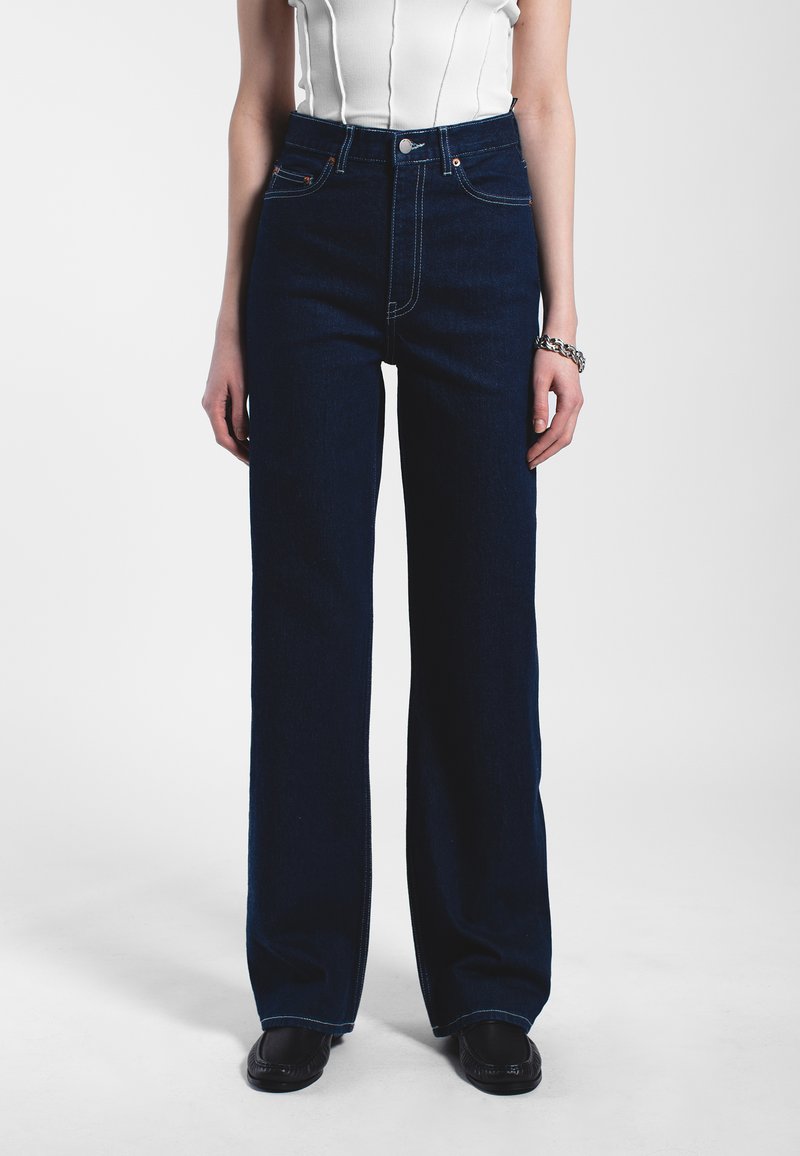 Hoge taille, wijde donkerdenim jeans met contrasterende stiksels, voorkeurszakken en een klassieke klinknagelknopsluiting.