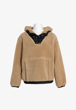 Beiger Fleece-Hoodie mit schwarzem gestepptem Reißverschluss-Detail am Kragen und vorderer Kängurutasche auf einer weißen Schaufensterpuppe.