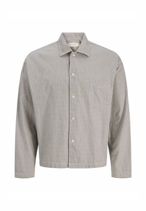 Klātu krekls ar pogām bungu krāsās, ar izplestu apkakli, garām piedurknēm, krūšu kabatu un brīvu piegriezumu. Kokvilnas maisījuma audums.