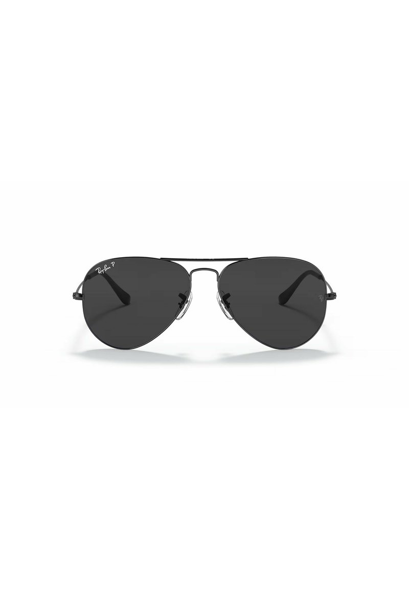 Occhiali da sole aviatori con lenti nere, montatura in metallo e dettagli in argento. Presentano una forma a goccia classica e un branding Ray-Ban ad alto contrasto.