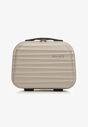 Valigia rigida beige con design a coste, hardware argentato, maniglia superiore e logo. La base presenta piedini protettivi per maggiore stabilità.