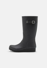 Botte de pluie noire en caoutchouc, design haut avec une semelle texturée, bout rond et détail de boucle ajustable sur le côté. Matériau lisse et imperméable.