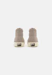 Grå semsket høye sneakers med hvit såle, med en logo på hælen og subtile sømdetaljer.