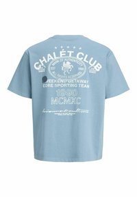Modré tričko s krátkym rukávom s bielym vintage textom a grafikou na chrbte, ktoré súvisia s "Chalet Club" a "1990 MCMXC".