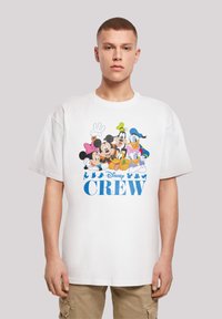 Hvit bomull t-skjorte med tegneserieillustrasjoner av Disney-figurer og teksten "Disney CREW" i blått, korte ermer og en avslappet passform.