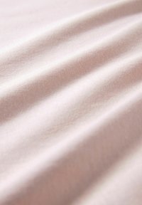 Helles rosa Stoff mit einer glatten Textur, der sanfte Falten und ein dezentes Webmuster zeigt, was ein weiches und einheitliches Erscheinungsbild schafft.