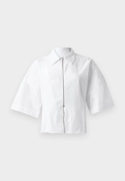 Witte blouse met korte mouwen, een kraag en een rits aan de voorkant. Glad textuur met een minimalistisch ontwerp, zonder patronen of accenten.