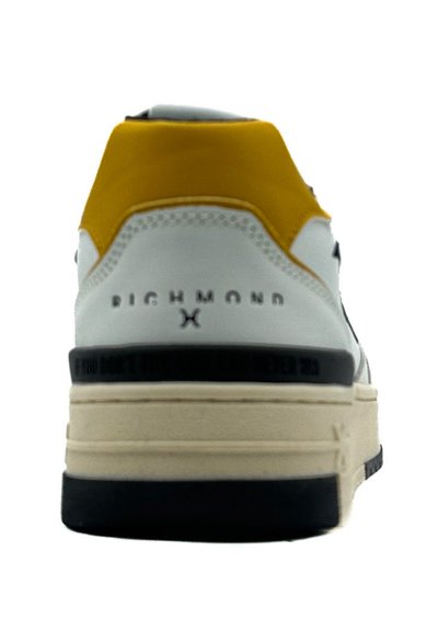 Sneaker bianco con tacco giallo, dettagli neri e suola spessa beige. Presenta il nome del marchio "RICHMOND" in rilievo sul retro.