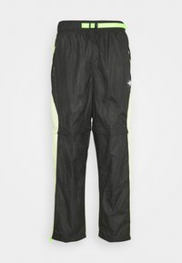 Svarta lätta byxor med mesh-sidpaneler. Har neongröna detaljer, elastisk midja med justerbar spänne och dragkedjedetaljer vid bensluten.