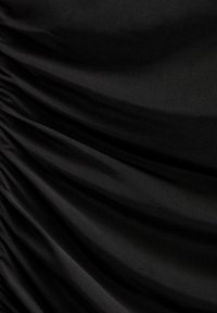 Tissu noir présentant une texture froncée, une surface lisse et un léger éclat. Le matériau drape élégamment avec un motif uniforme.