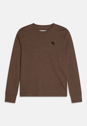 Camiseta marrón de manga larga con cuello redondo y pequeño logo negro de alce bordado en el pecho izquierdo, extendida sobre fondo blanco.