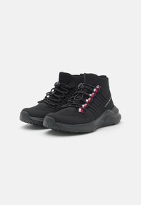 Zwarte enkelschoenen voor sportgebruik met een bovenkant van mesh, elastische veters en een gestructureerde zool. Heeft kleurrijke accenten aan de zijkant.