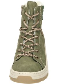 Bottine en cuir vert avec doublure en fausse fourrure, coutures contrastantes claires et lacets tressés. Dotée d'une semelle en caoutchouc robuste et d'une fermeture éclair.