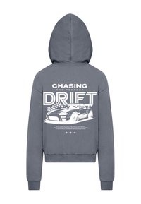 Siva kapuca s sweatshirtom, ki vsebuje bel grafični tisk dirkalnika in napis "ISKANJE POPOLNEGA DRIFTANJA" na hrbtni strani.