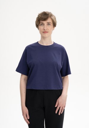Korte mouw navyblauw katoenen T-shirt met een ronde halslijn en een cropped ontwerp, gecombineerd met zwarte broek.