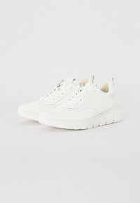 Białe sneakersy z teksturowaną cholewką, okrągłym czubkiem i amortyzowaną podeszwą. Posiadają sznurowane zapięcie oraz małą pętelkę na pięcie.