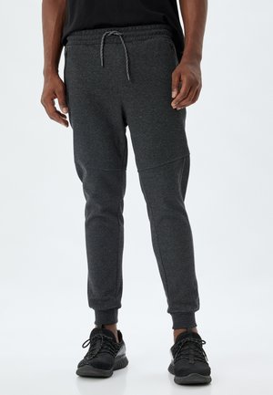 Grå joggerbukser med snøre i taljen, tapered fit, ribbet manchetter og sidelommer med lynlås. Lavet af tekstureret, strækbart materiale.