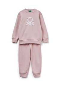 Różowa bluza i dopasowane spodnie z miękkiego materiału. Posiada białą grafikę z przodu. Mankiety i pas są ściągacze.