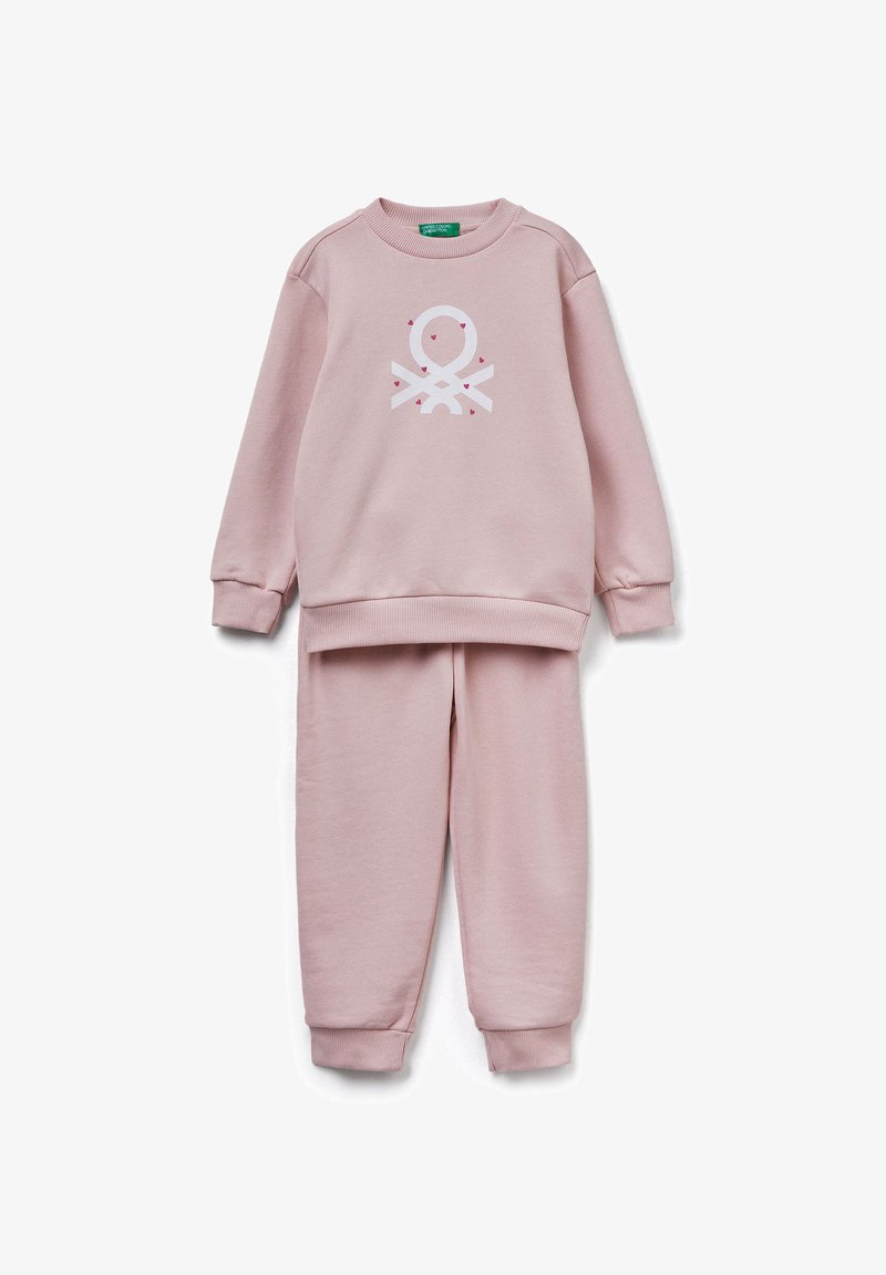 Różowa bluza i dopasowane spodnie z miękkiego materiału. Posiada białą grafikę z przodu. Mankiety i pas są ściągacze.