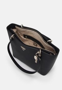 Černá kožená taška přes rameno se stříbrnými detaily, zipovým uzávěrem a béžovým interiérem. obsahuje vnitřní zipovou kapsu a akcenty s logem.