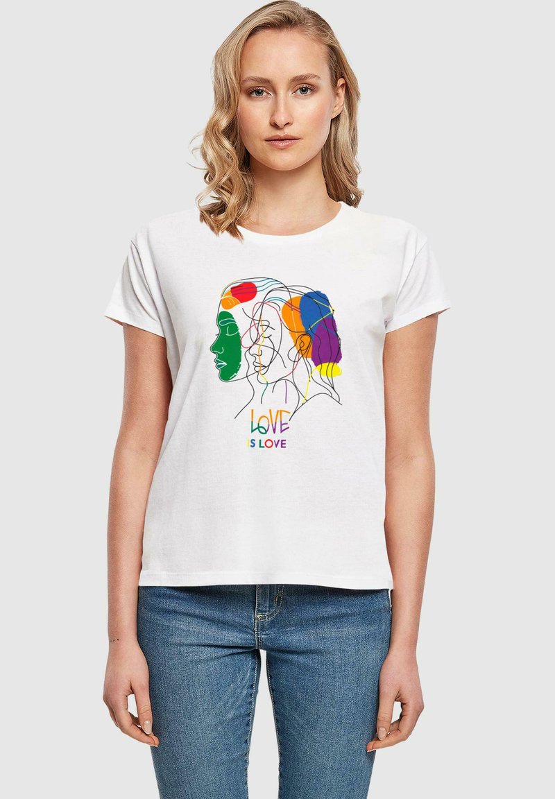 T-shirt bianca in cotone con un design di profili in line art colorata e il testo "L'AMORE È AMORE" in colori vivaci. Maniche corte e vestibilità morbida.