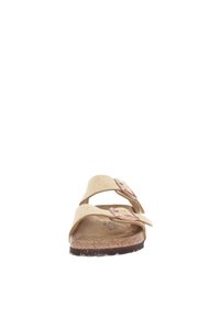 Sandalias deslizantes de ante beige con dos correas ajustables, cada una con una hebilla metálica. Plantilla texturizada y suela de goma marrón.
