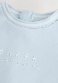 Helles blaues Sweatshirt mit Rundhalsausschnitt, ausgestattet mit weißen Streifenakzenten und erhabenen "BAKER"-Text auf der Vorderseite. Glatter Baumwollmischstoff.