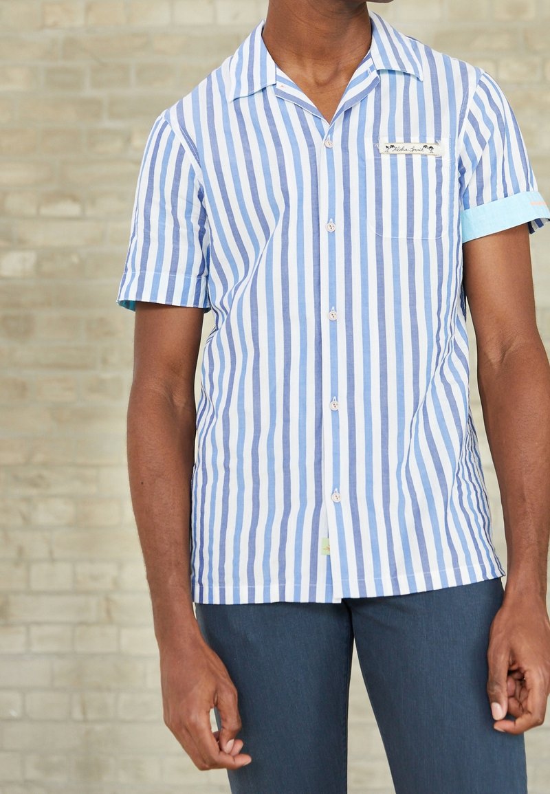 Camisa de manga corta con rayas verticales en azul y blanco, de algodón, que cuenta con un bolsillo en el pecho y detalles en los puños en azul claro.