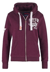 Sudadera con capucha y cremallera en color granate, mezcla de algodón, con un estampado frontal que dice "Super Dry", cordones blancos y dos bolsillos delanteros.