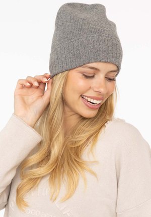 Gray knitted beanie with a ribbed design, featuring a folded cuff and a soft texture. Worn snugly on the head, adds warmth and style.