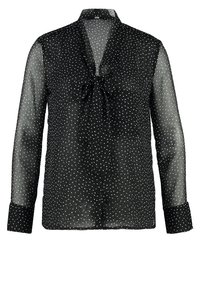 Schwarze, transparente Bluse mit langen Ärmeln, die weiße Polka-Punkte und eine Schleifen-Detail am Kragen aufweist. Knopfverschluss vorne.