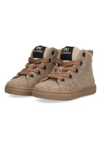 Lichtbruine hoge sneakers met geperforeerde bovenkant, bruine veters en een zwarte tong met de tekst "Wees jezelf". Gestructureerde rubberen zool.