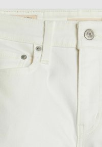 Jeans de mezclilla blanca con un corte clásico, cierre frontal con botón, acentos de hardware plateado y tela texturizada.