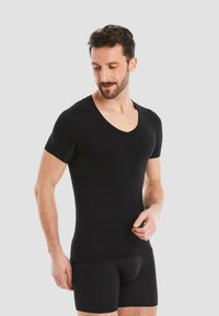 Black short-sleeve V-neck shirt made of smooth, stretchy material, fitted style, worn with matching black shorts.
