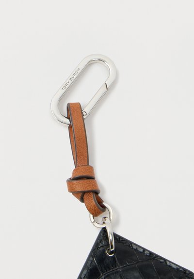 Μαύρο δερμάτινο μπρελόκ με υφή, με καφέ δερμάτινη θηλιά και ασημένιο καραμπίνερ με χαραγμένο το όνομα της μάρκας.