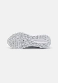 Semelle de sneaker blanche avec un motif de grip texturé et un logo Swoosh Nike embossé au centre, affichée sur un fond blanc.