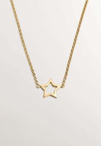 Collar de cadena de oro que presenta un colgante en forma de estrella hueca. La estrella tiene un acabado liso y pulido, con un diseño geométrico y longitud ajustable.