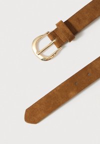 Καφέ ζώνη από σουέντ με αγκράφα από μέταλλο σε χρυσή απόχρωση. Η ζώνη έχει πλάτος περίπου 3 εκ., με πολλές τρύπες ρύθμισης κατά μήκος της.