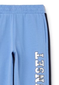 Lichtblauwe sweats met een elastische tailleband, zijzakken en zwarte zijkanten. Voorzien van gedurfde "SUNSET" letters in metallic zilver.