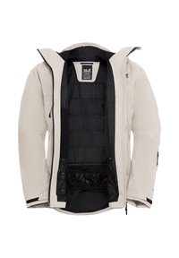 Giacca impermeabile beige con cappuccio, foderata con un tessuto trapuntato nero, chiusura frontale con zip e tasca interna. Presenta zip e dettagli a contrasto di colore scuro.