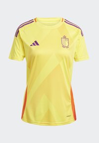 Keltainen urheilu paita purppuran yksityiskohdilla, jossa on vinomalleja ja adidas-logo. Sisältää vaakunat rinnassa ja ventiloidut sivut.