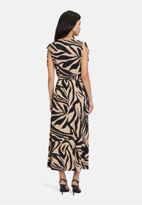Maxikleid aus beigem Stoff mit einem schwarzen Zebra-Print. Verfügt über Bindebänder an den Ärmeln und eine taillierte Taille. Glatte, leichte Textur.
