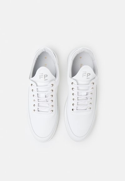 Las zapatillas de lona blancas cuentan con una puntera redonda, ojetes de metal, cordones planos y un logotipo en la lengüeta. Tienen una textura suave con un perfil esbelto.
