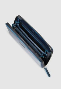 Donkerblauwe leren portemonnee met ritssluiting, meerdere vakken en contrasterende blauwe accenten langs de randen en aan de binnenkant.