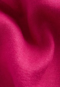 Fuchsia-Stoff mit einer weichen Textur, der ein dezentes gewebtes Muster und glatte, sanft geschwungene Falten aufweist.