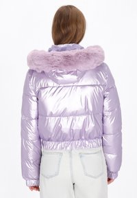 Púderes anyagú, párnázott kabát csillogó levendula színben, puha lila szőrme gallérral, rugalmas derékpánttal és bordázott mandzsettákkal.