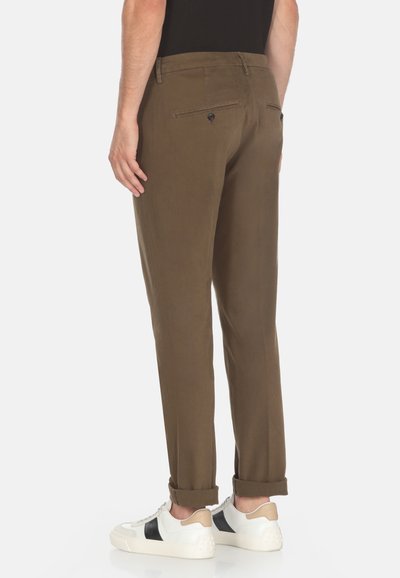 Chinos di un verde oliva scuro con una superficie liscia, vestibilità affusolata, orli arrotolati e due tasche posteriori con chiusura a bottone. Design con frontale piatto.