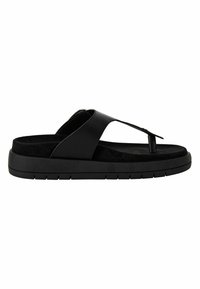 Sandalias negras con diseño de tira entre los dedos, que cuentan con una suave plantilla de ante y una suela de goma texturizada. Las correas están hechas de un material sintético suave.